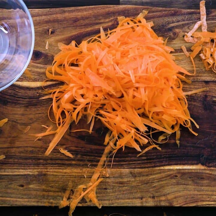 Shaved carrots on a cutting board.