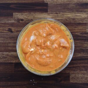 A bowl with chicken tenders in a marinade.