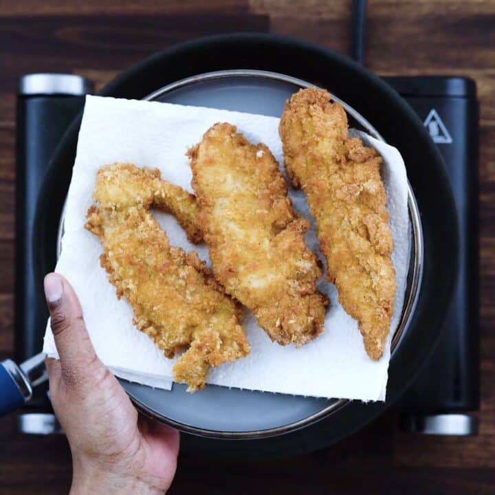 Fried Chicken Tenders on a plate with kitchen towel.