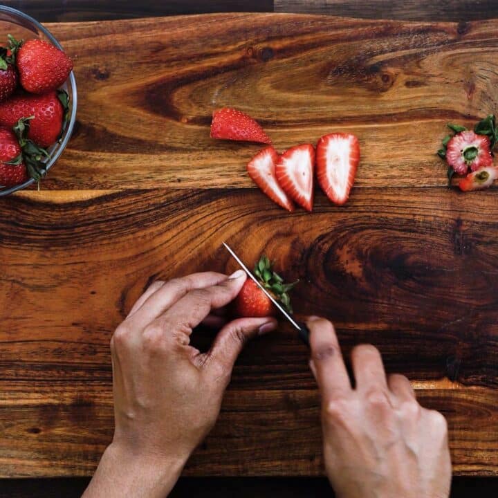Slicing the strawberries using knife.