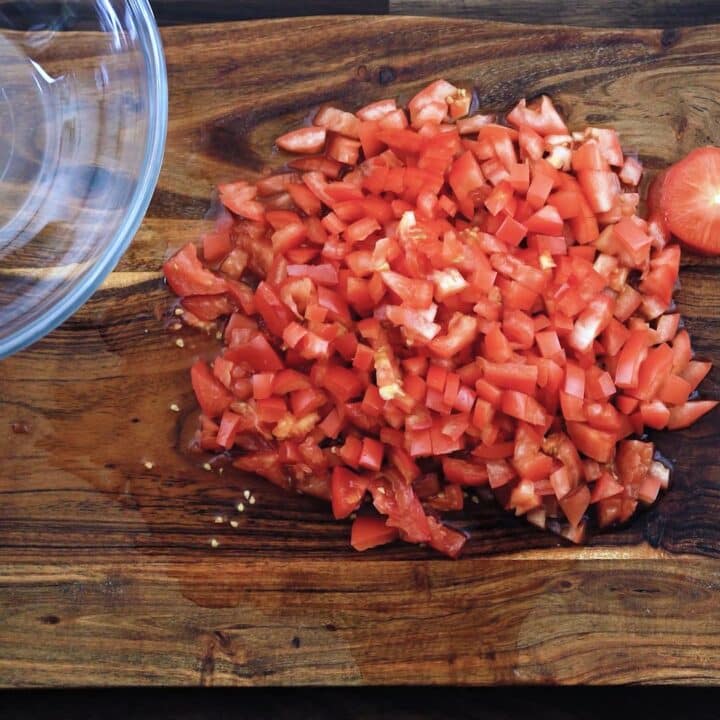 Finely diced tomatoes on a cutting board.