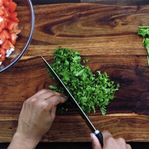 Chopping the coriander leaves using a knife.