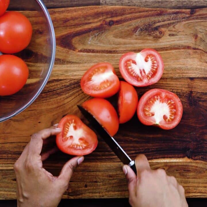 Slicing the tomatoes in half.
