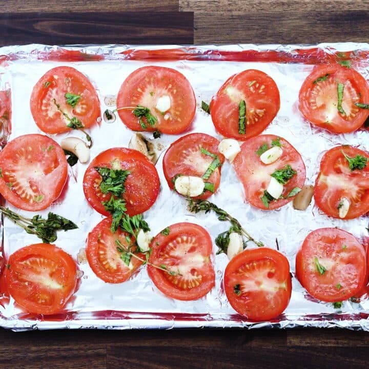 A baking tray with seasoned tomatoes.