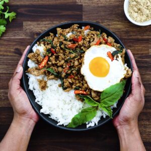 Serving Thai Basil Chicken over rice and fried egg alongside.