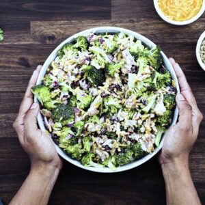 Serving Broccoli Salad in a white bowl.