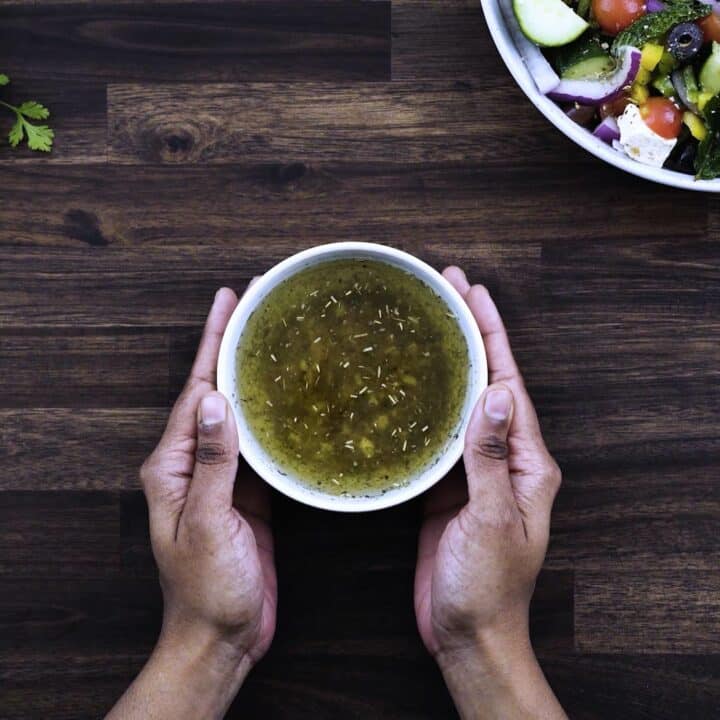 Serving Greek Salad dressing in a white bowl.