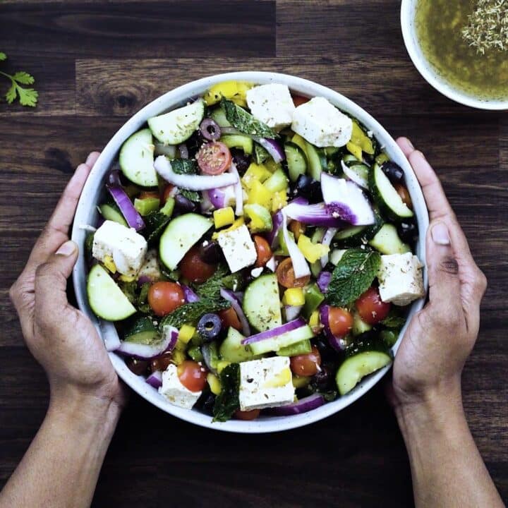 Serving Greek Salad in a white bowl.