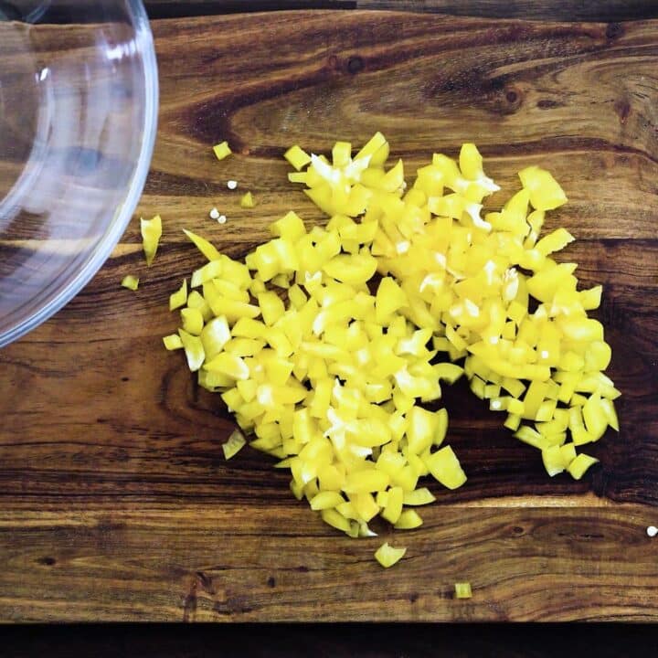 Diced yellow bell pepper on a cutting board.