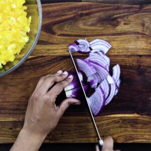 Slicing the red onions using a knife.