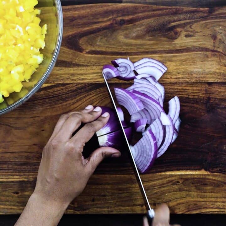 Slicing the red onions using a knife.