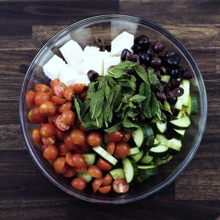 A bowl with Greek Salad ingredients.