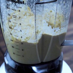 A blender with crumbly hummus ingredients.