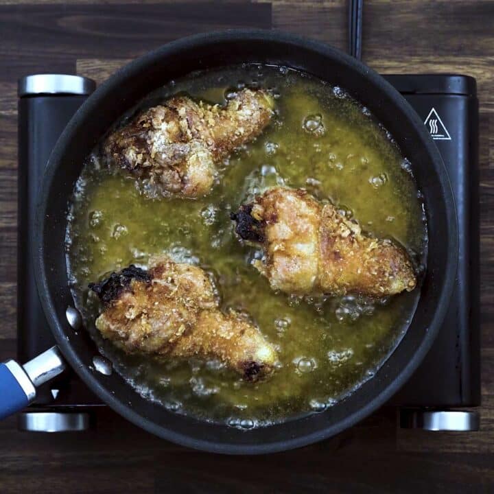 Double frying the chicken drumsticks in oil.