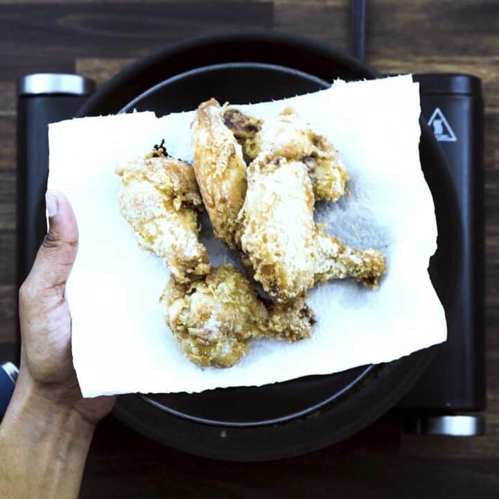 Fried Chicken Wings in a black plate lined with tissue paper.