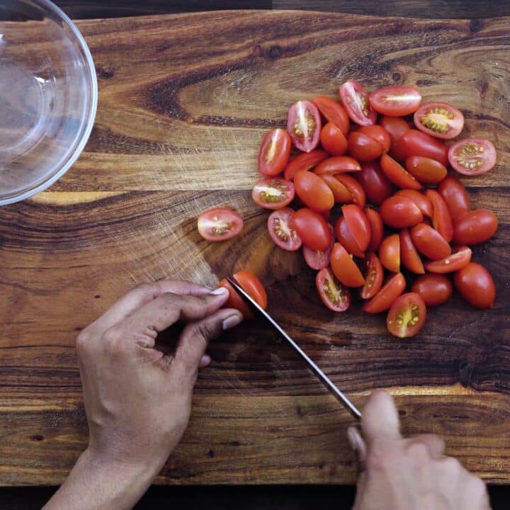 Slicing the grape tomatoes in half.
