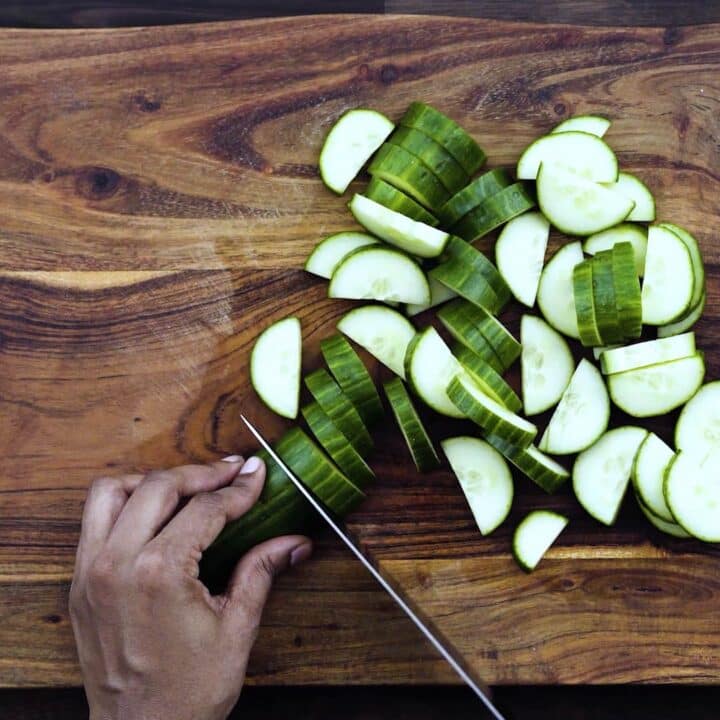 Slicing the cucumber using a knife.