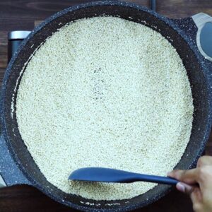 Toasting the sesame seeds in a wide pan.