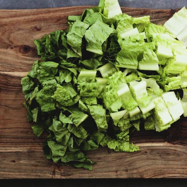 Chopped romaine lettuce on a cutting board.