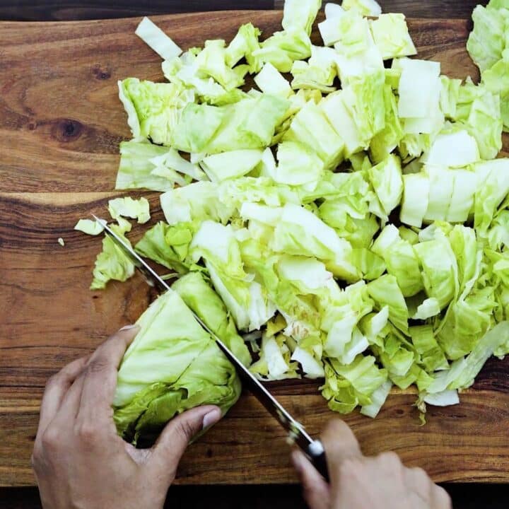 Cutting the iceberg lettuce using a knife.