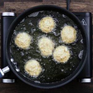 Round Hush Puppy mixture frying in oil.