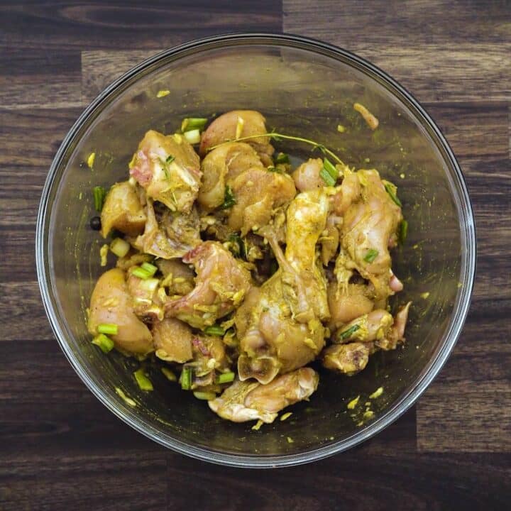 A bowl with marinated chicken pieces.