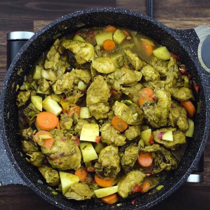 A pan with chicken, potatoes and carrots.