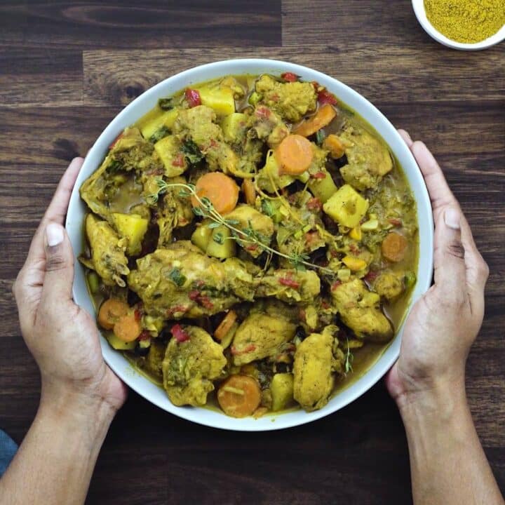 Serving Jamaican Curry Chicken in a serving bowl.