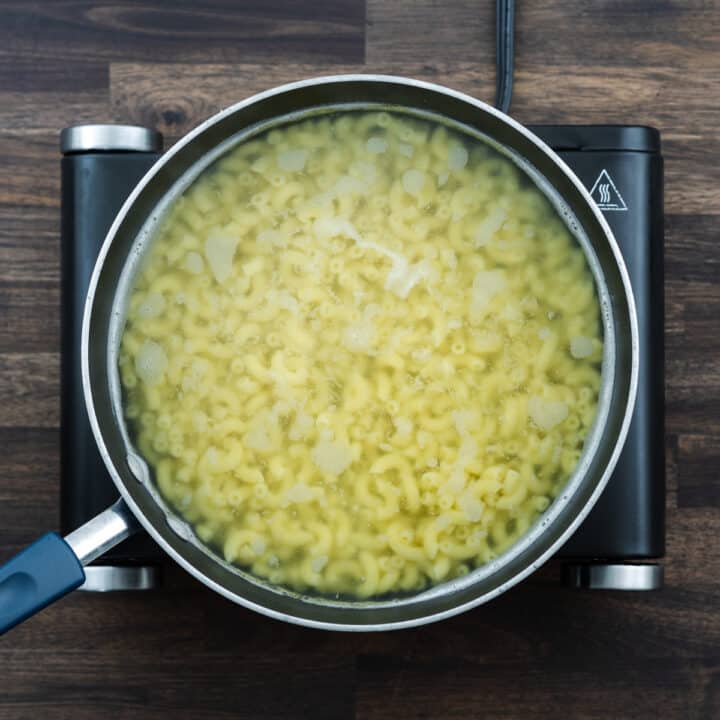 A pan with Macaroni Pasta in simmering water.