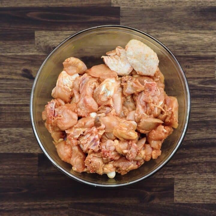 A bowl with marinated chicken.
