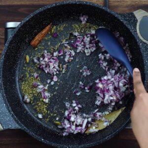 Sautéing whole spices and onions until fragrant.