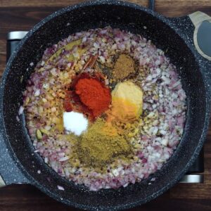 A pan with spice powders along with sauteed onions.