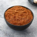 Chicken seasoning mix or dry rub in a black bowl on a white tabletop.