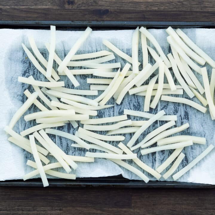 Soaked potato strips allowed to dry in tray lined with paper towel.
