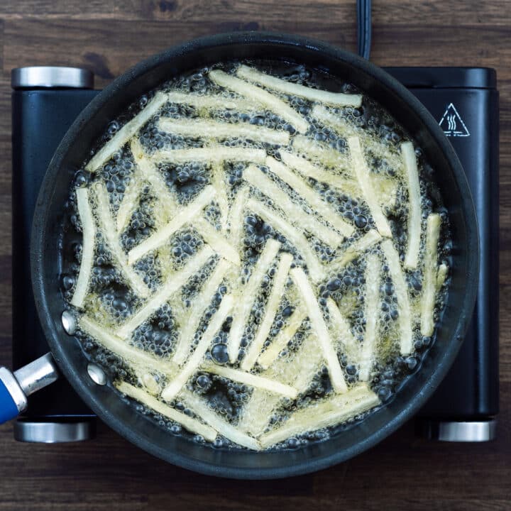 French fries being first fried and then undergoing a second frying in hot oil.