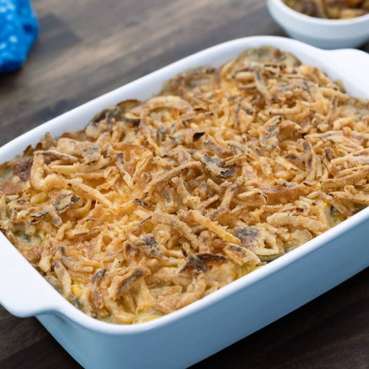 Green Beans Casserole in a baking dish with fried onions alongside.
