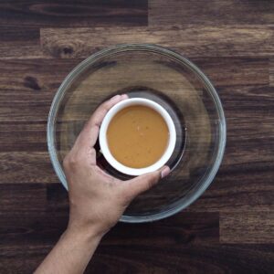 Adding honey to the glass bowl.