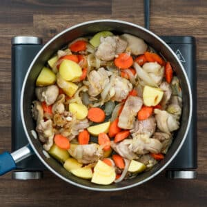 A pan with chicken, carrots and potatoes sauteed altogether.