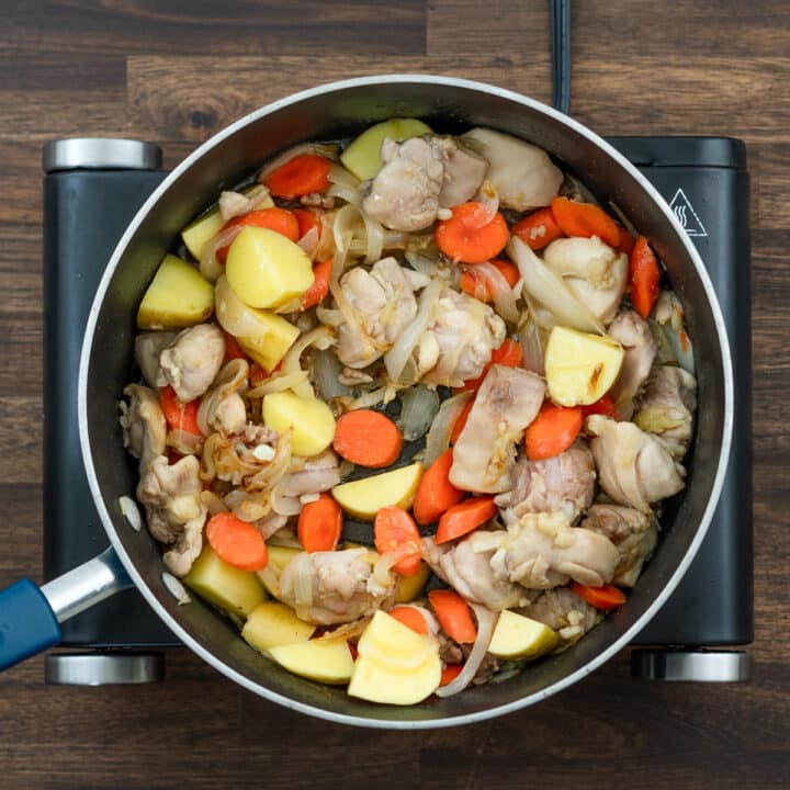 A pan with chicken, carrots and potatoes sauteed altogether.