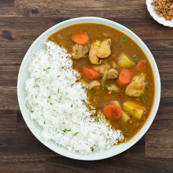 Japanese Chicken Curry served with a bed of rice in a white bowl.
