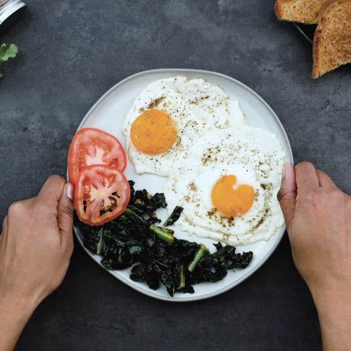 Serving the Sunny side up egg with sauteed kale and tomatoes.