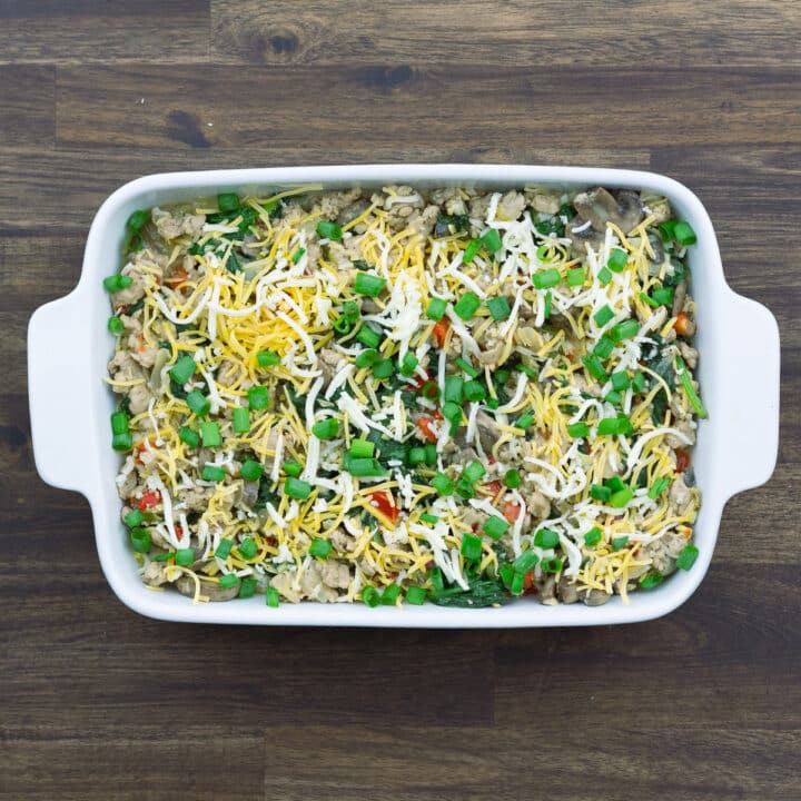 A baking dish with casserole mixture topped with cheese.