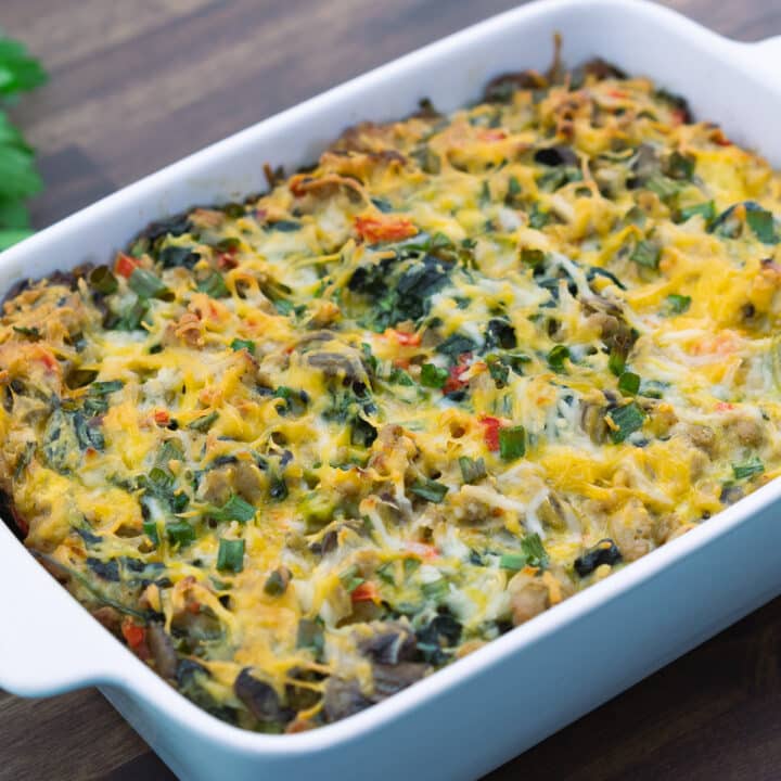 Breakfast Casserole in a baking dish and some herbs on the side.
