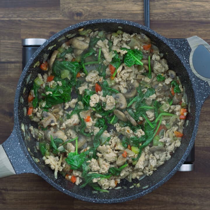 A pan with veggie meat mixture along with spinach.