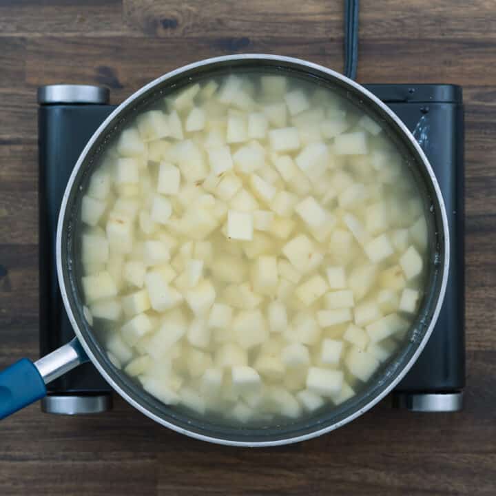 A pan with diced potatoes filled in water.