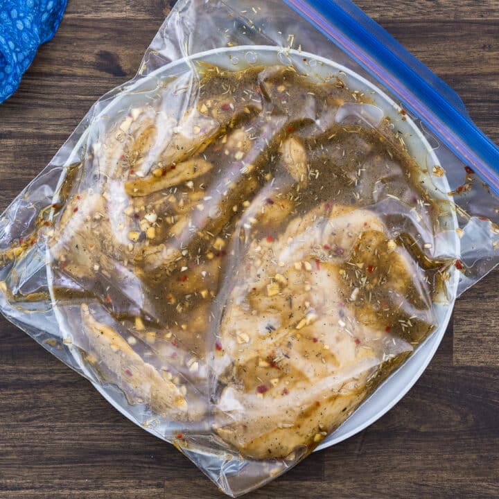 Chicken breast inside a ziplock bag marinated with marinade.