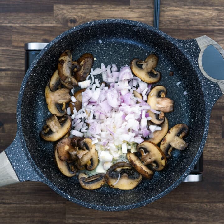 A pan with mushrooms, garlic and onions.