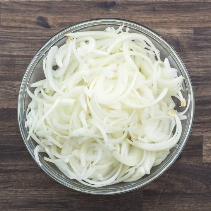 Sliced and separated onions in a bowl.