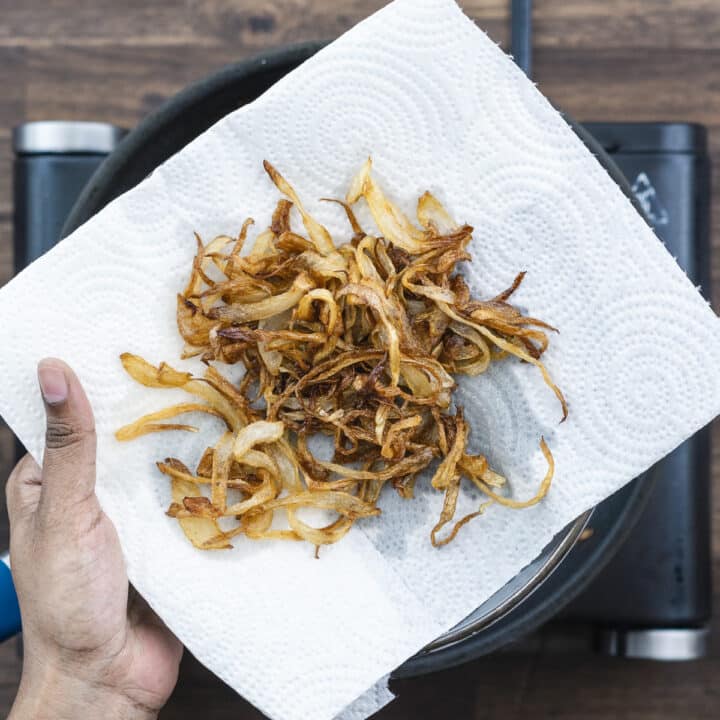 Golden brown classic fried onions on a tissue paper.