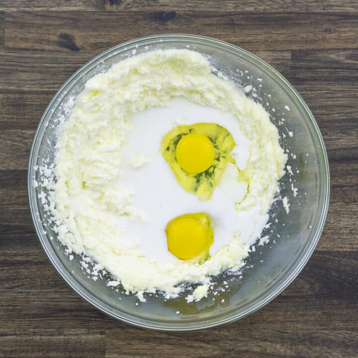 A bowl with butter mixture along with eggs and milk.